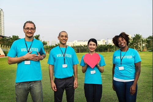 Group of volunteers standing outdoors looking cheerful